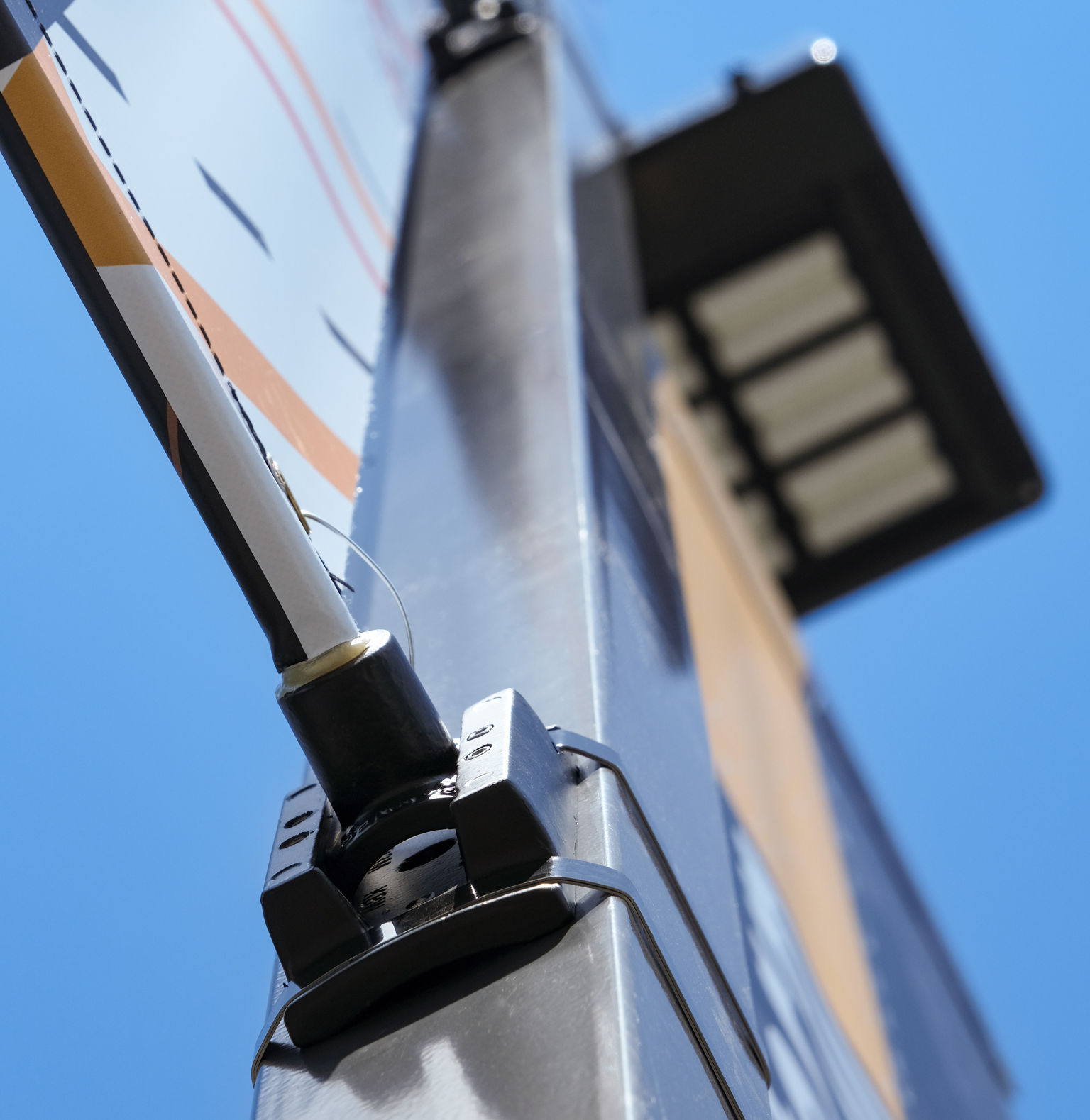 Detailed photo of pole banner hardware and bands wrapping around a square pole.