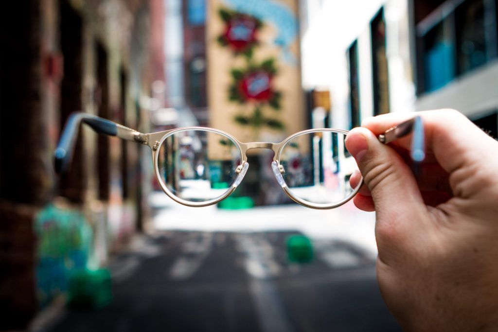 View through a pair of spectacles held out in a person's hand