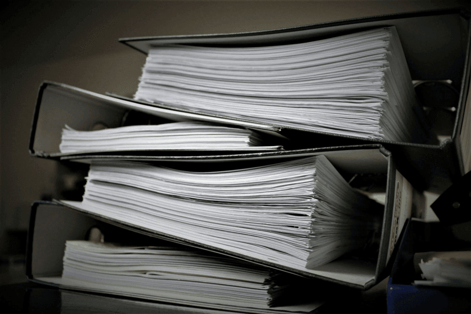 Stack of legal documents organized in binders.