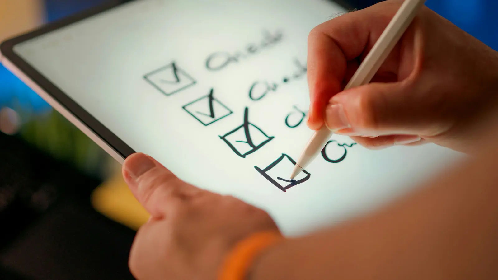 A hand using a stylus to tick boxes on a checklist displayed on a tablet.
