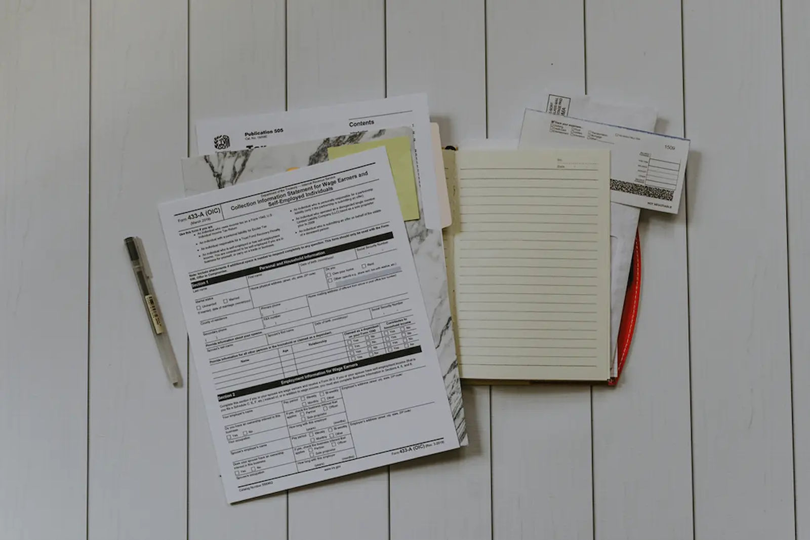 Lease paperwork on a desk with a pen and notebook, symbolizing reviewing lease terms.