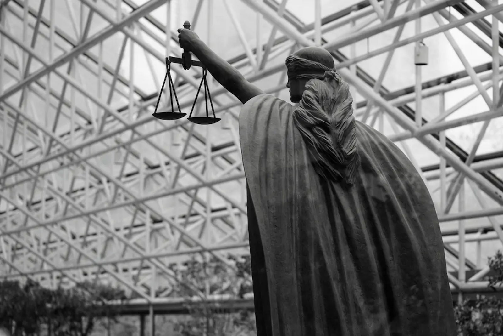 Black-and-white justice statue with scales, symbolizing U.S. commercial lease regulations.