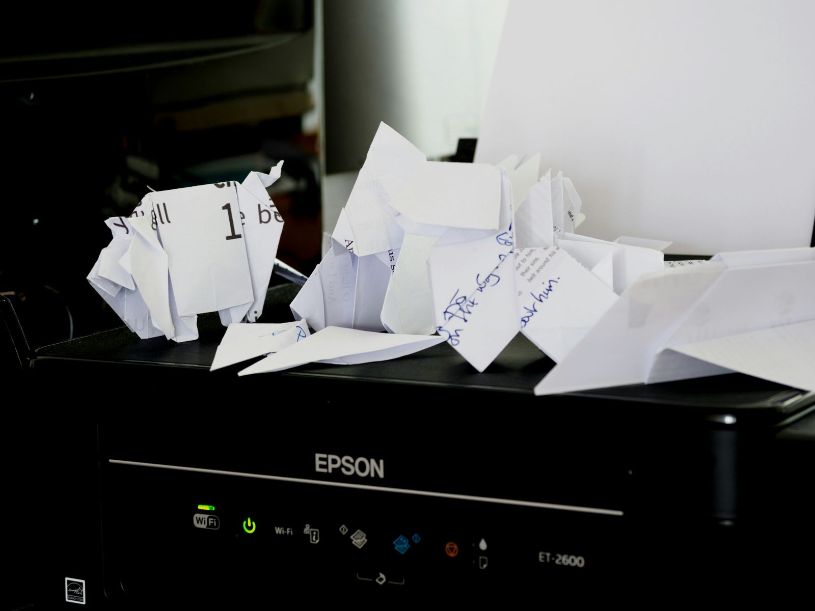 Crumpled paper and scraps piled on top of a printer, suggesting paperwork mistakes