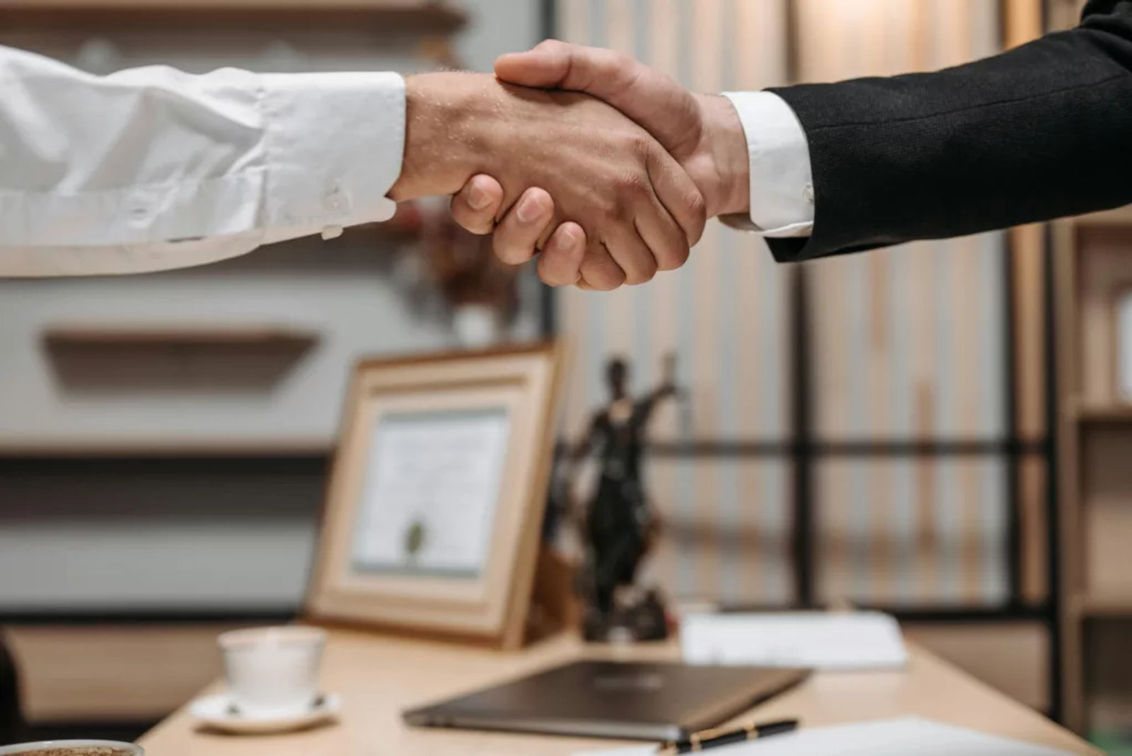 Lawyer and client shaking hands after a legal agreement.