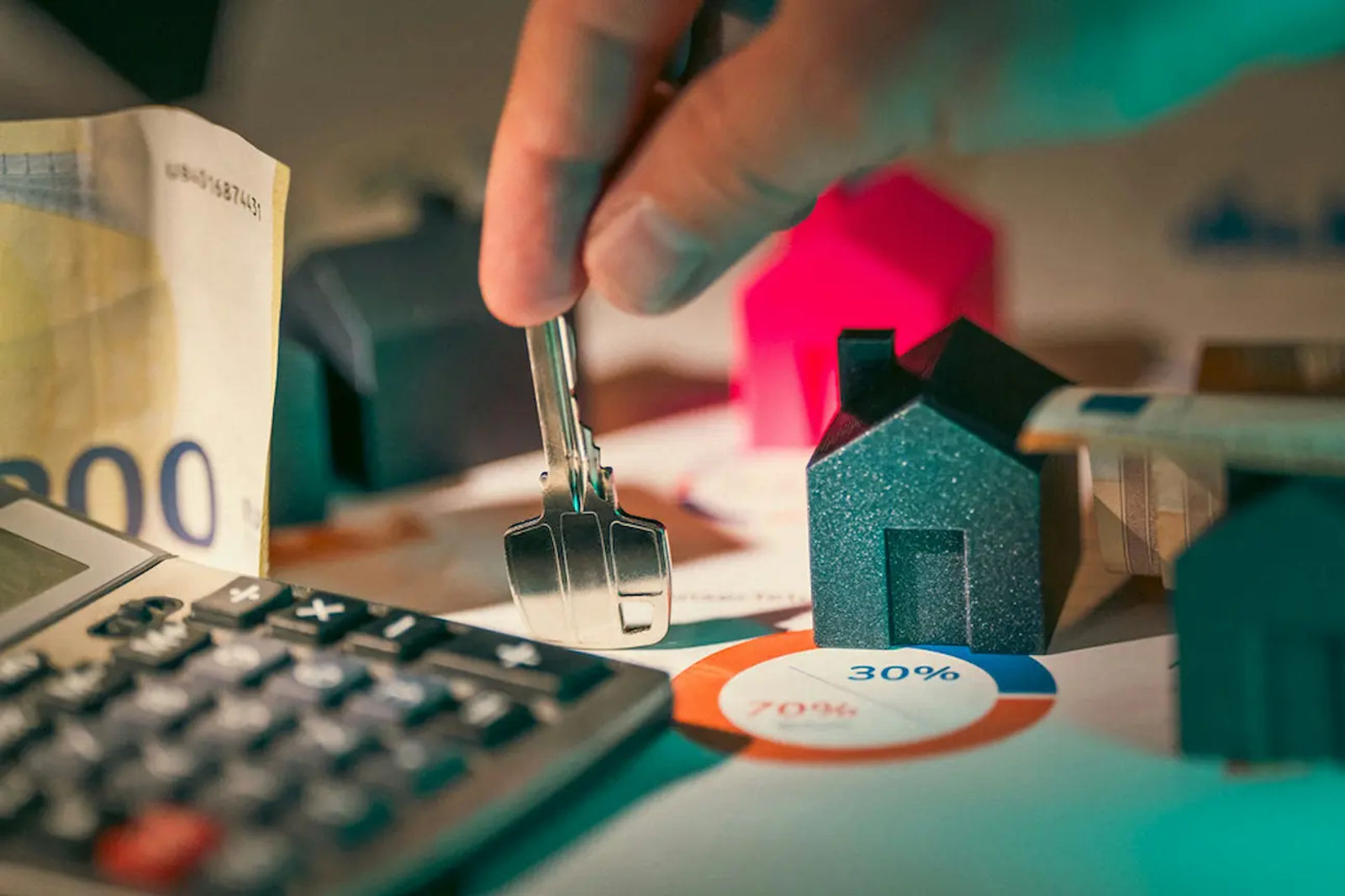 Calculator, cash, and property key on documents, symbolizing commercial lease agreement terms.
