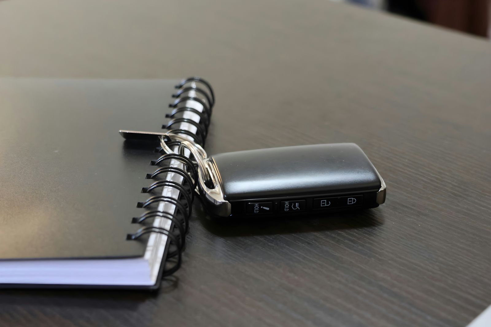 Car key fob on a notebook on a desk.