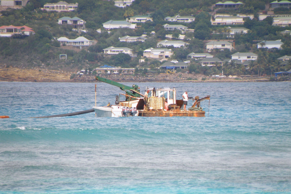 Boat in Saint-Jean Bay pumping sand to the beach during rehabilitation by Bureau Xavier David.