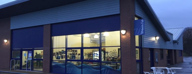 A cafe is lit up against a dark sky.