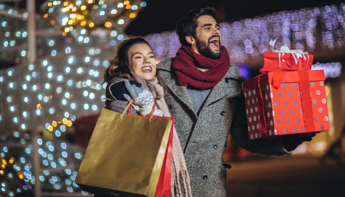 Couple out shopping at night surrounded by illuminations