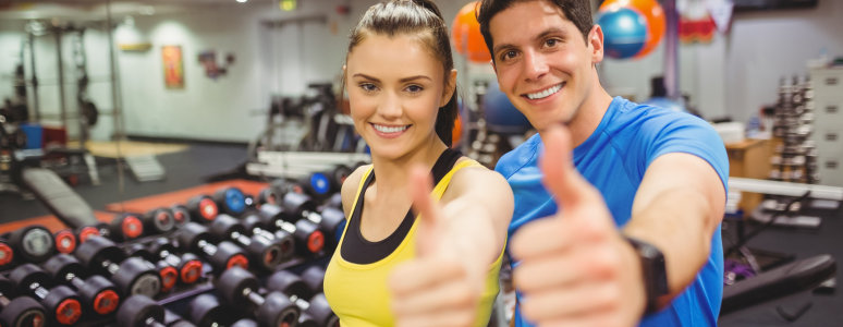 man and women in gym doing thumbs up to the camera