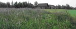 photograph with long grass in foreground and community building in background photograph with long grass in foreground and community building in background