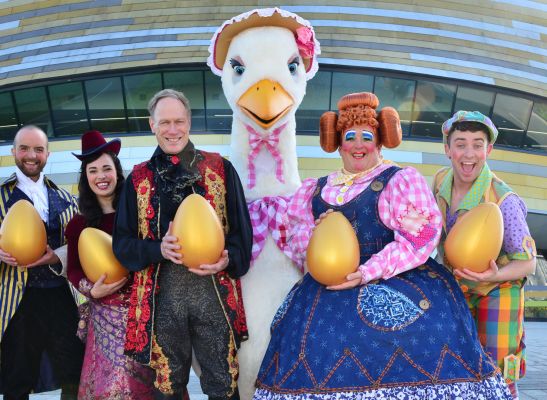 Dame and panto baddy stand beside a giant golden egg and the title Mother Goose