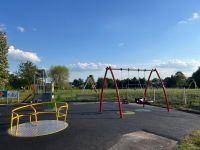 A park has a variety of park equipment, including as roundabout and swing that is accessible.