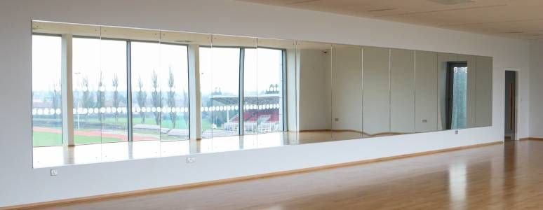 Wall mirrors in the fitness studio reflect a view of Moorways Stadium track