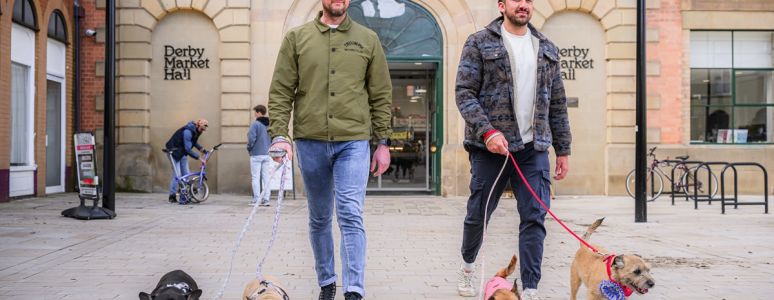 Men walking with dogs outside Derby Market Hall
