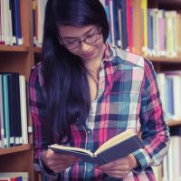 Girl_reading_book_in_library.jpg