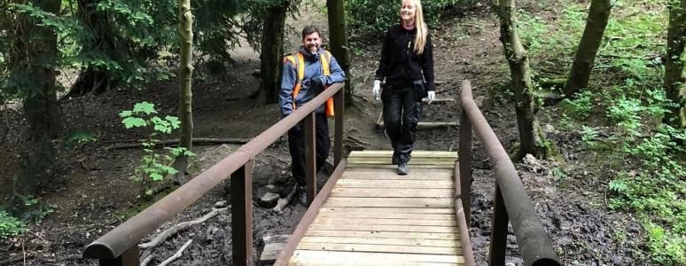 image shows two people fixing a bridge 