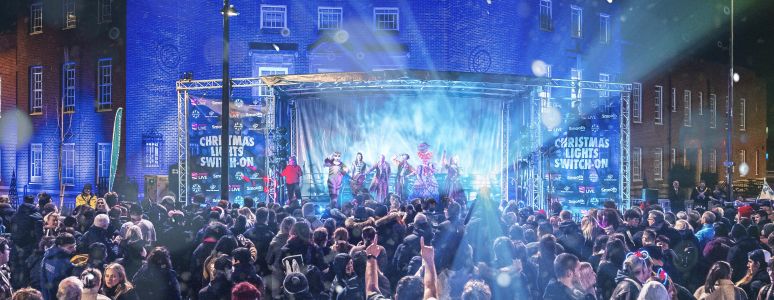 Shot of the stage from behind a crowd, celebrating the Christmas lights switch on