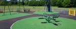 Image of playground showing a roundabout and swings