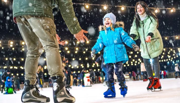 Child on ice rink and parent in foreground