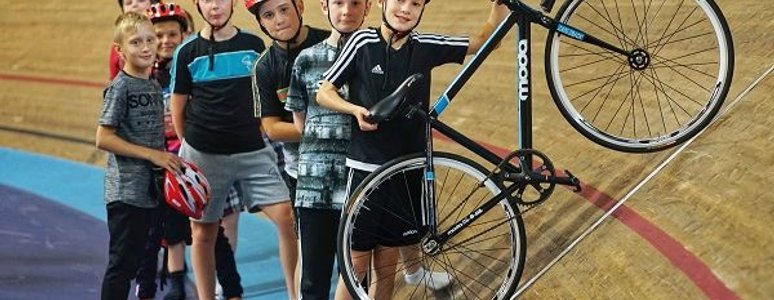 Children on cycling track with coach