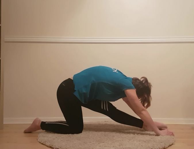 women stretching body forward towards foot