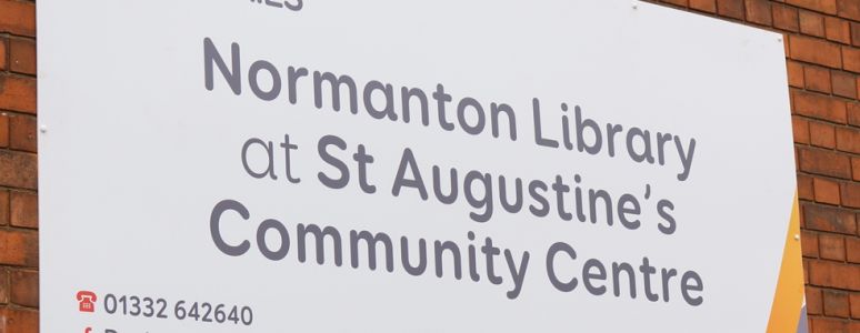 Sign saying Normanton Library at St Augustine's Community Centre on the outside brick wall of the building