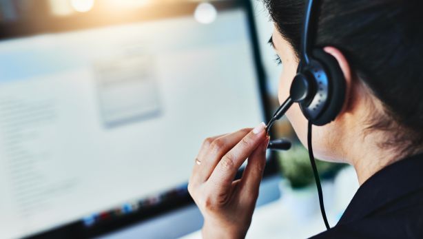 Woman in a headset looking at a computer screen
