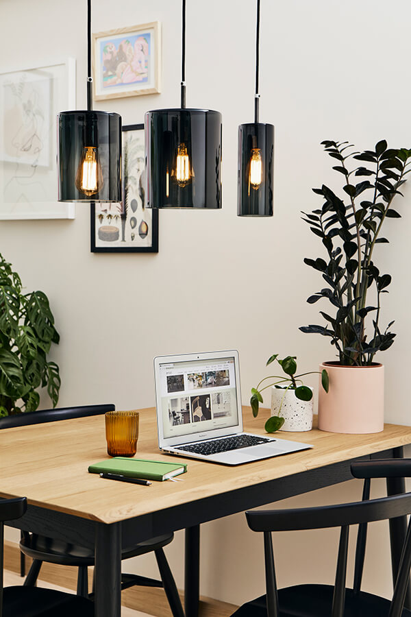Photography: Beth Davis www.beth-davis.co.uk An open laptop sat on a Monza dining table under black pendant lights