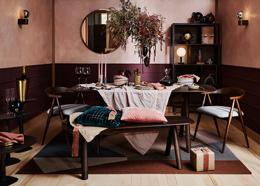 Photography: Lol Johnson Photography @still_loljohnsonphotography A contemporary, luxurious dining room dressed for Christmas featuring dark ercol dining furniture and dressed in shades of pink and green