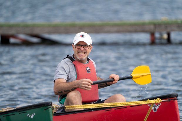 man smiling with paddle in canoe
