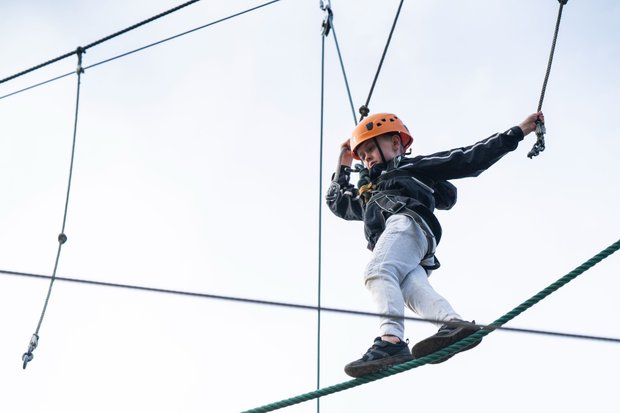 Child balancing on rope on high ropes