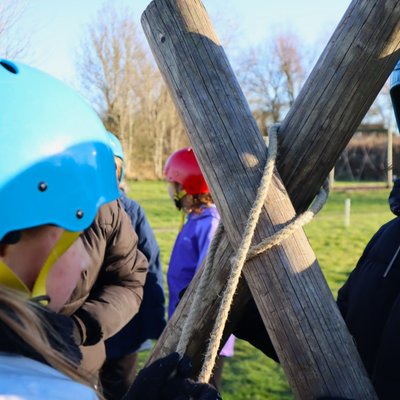 girl using rope to tie poles together