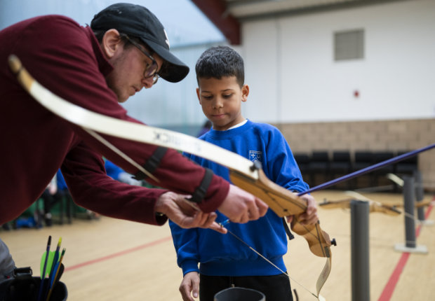 boy being taught archery