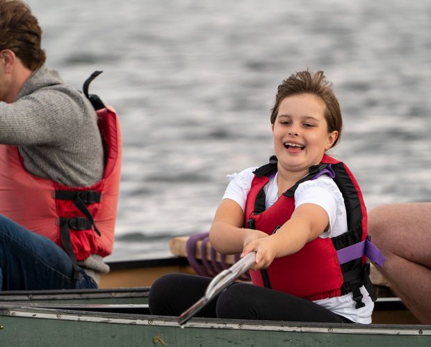 girl reaching with her paddle in canoeing