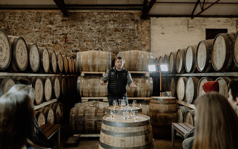 White Peak Distillery Tour guide talking amongst whiskey barrels