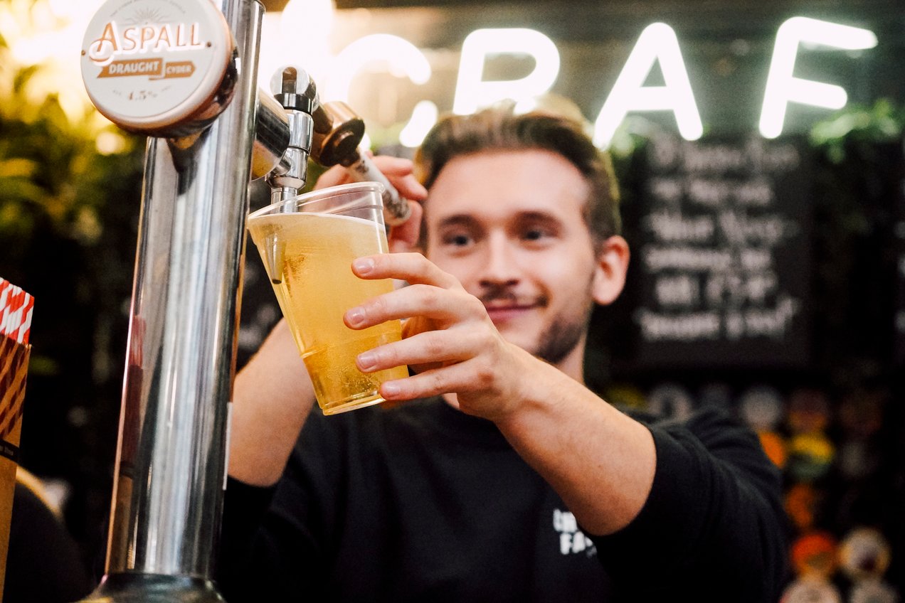 Bar man pouring beer at Bustler Market Derby