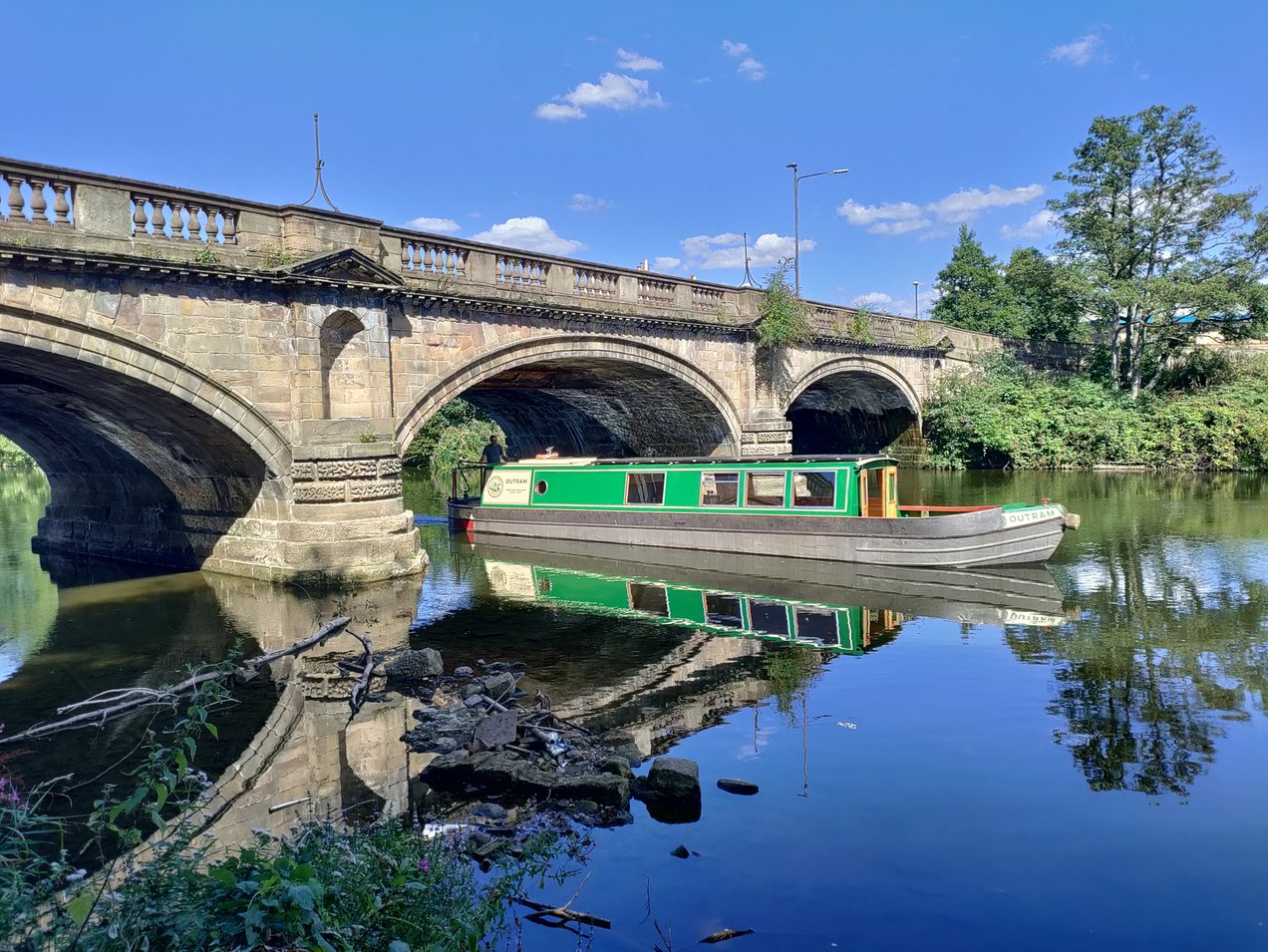 Riverboat sailing under a bridge