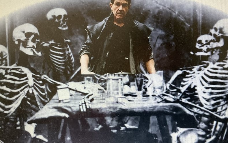 Richard Felix with skeletons at a dining table