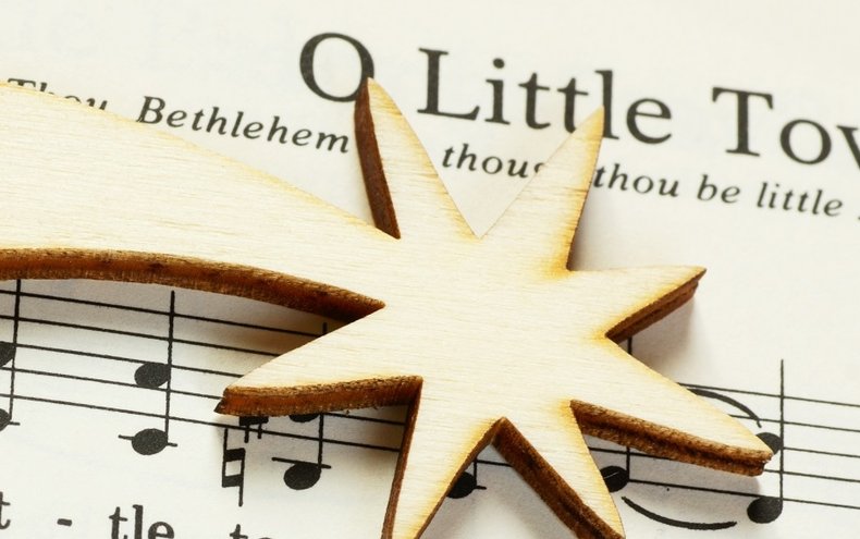 Wooden star on Christmas music sheet