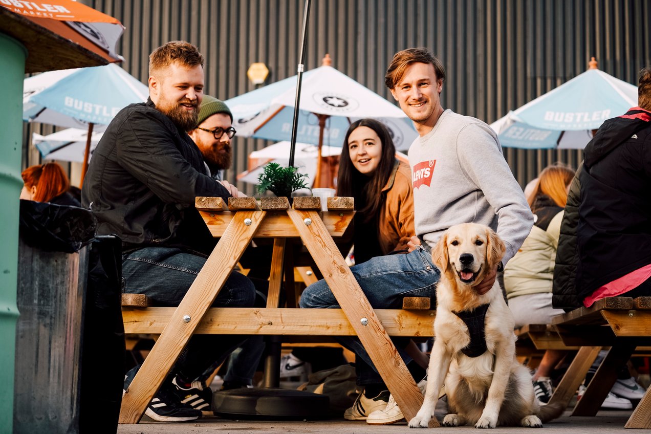 Image Credit: Averill Photography Friends seated outside at Bustler Market with light coloured dog