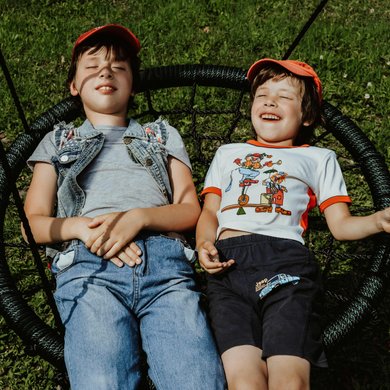 Cheerful boys swinging in park