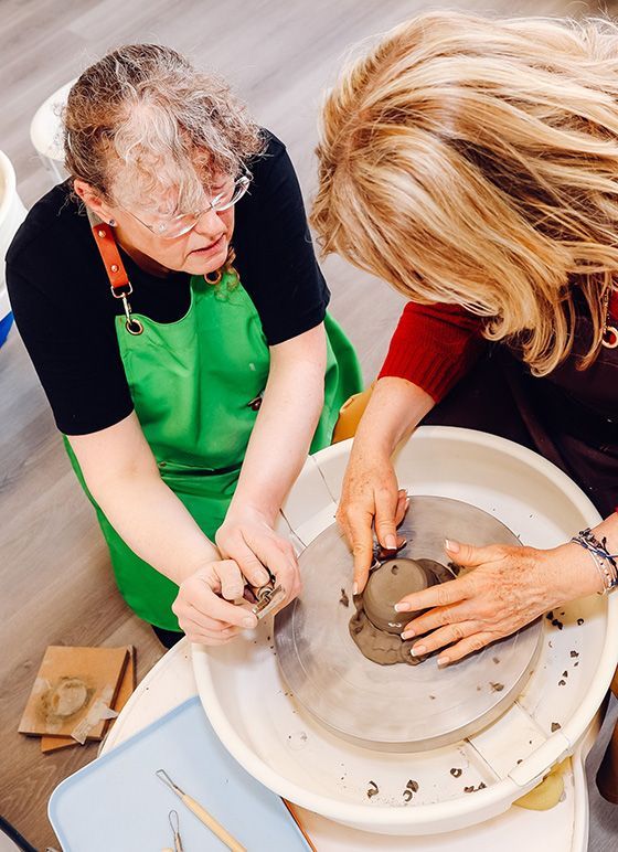 Two people at a pottery wheel