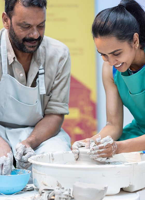 A couple having fun making pottery vases