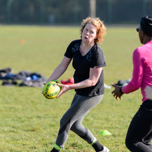 Women playing rugby on a field