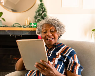 Older Black woman using a tablet at home to browse the internet