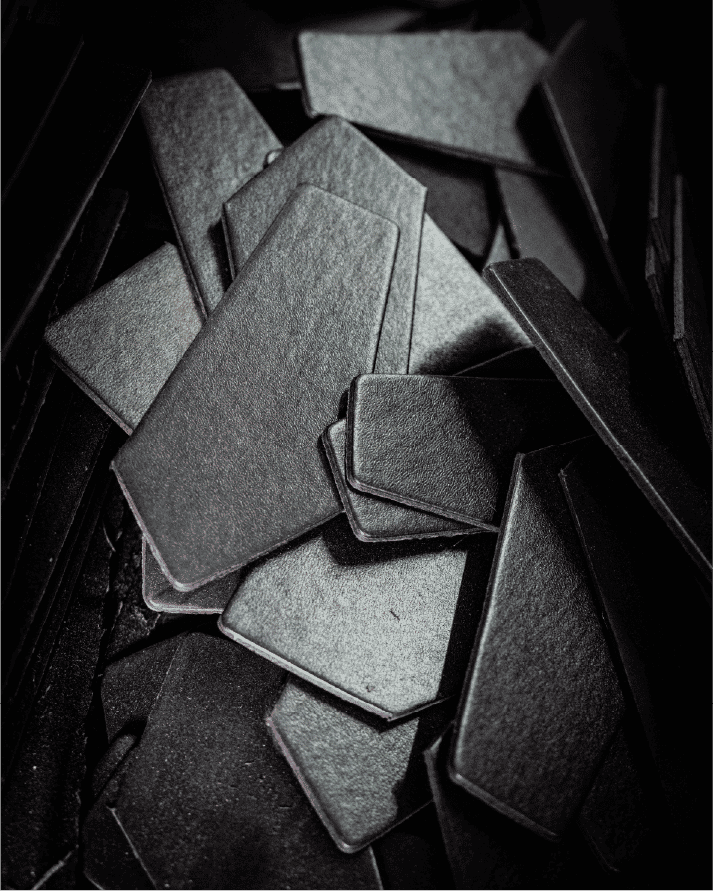 Assorted black textured cut pieces piled in container