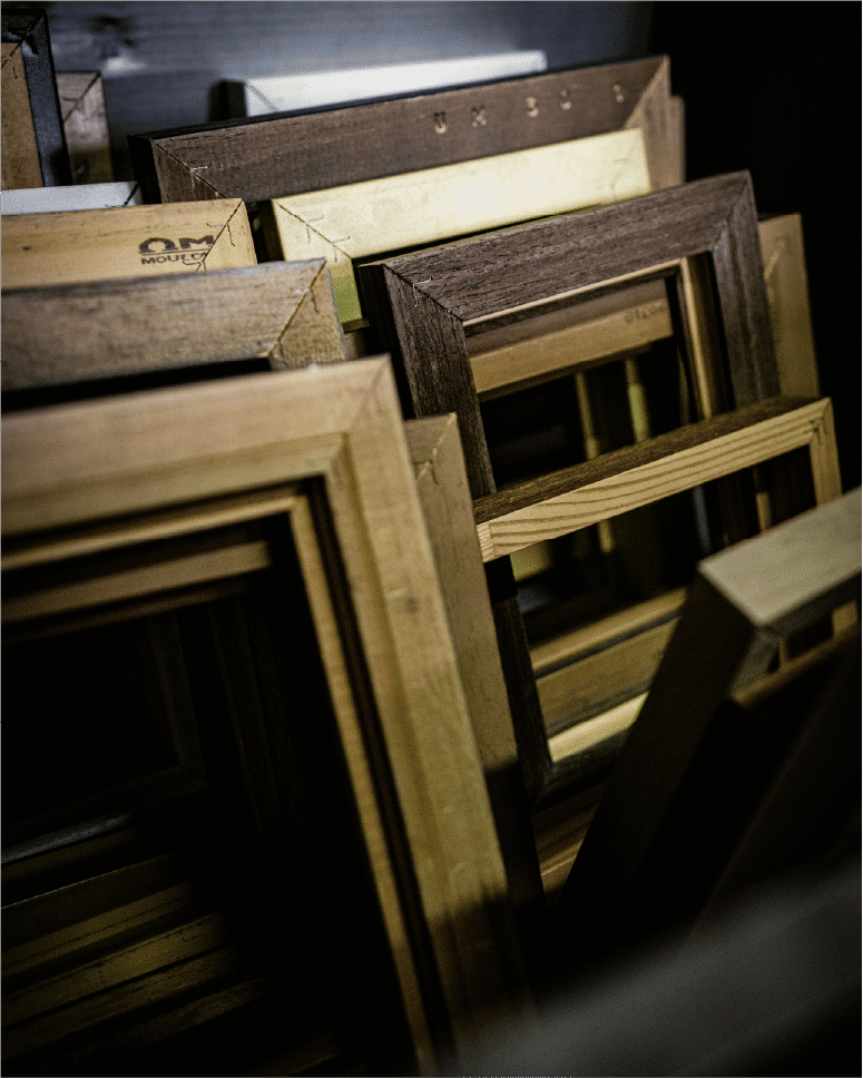 Stacked wooden frames awaiting assembly in workshop