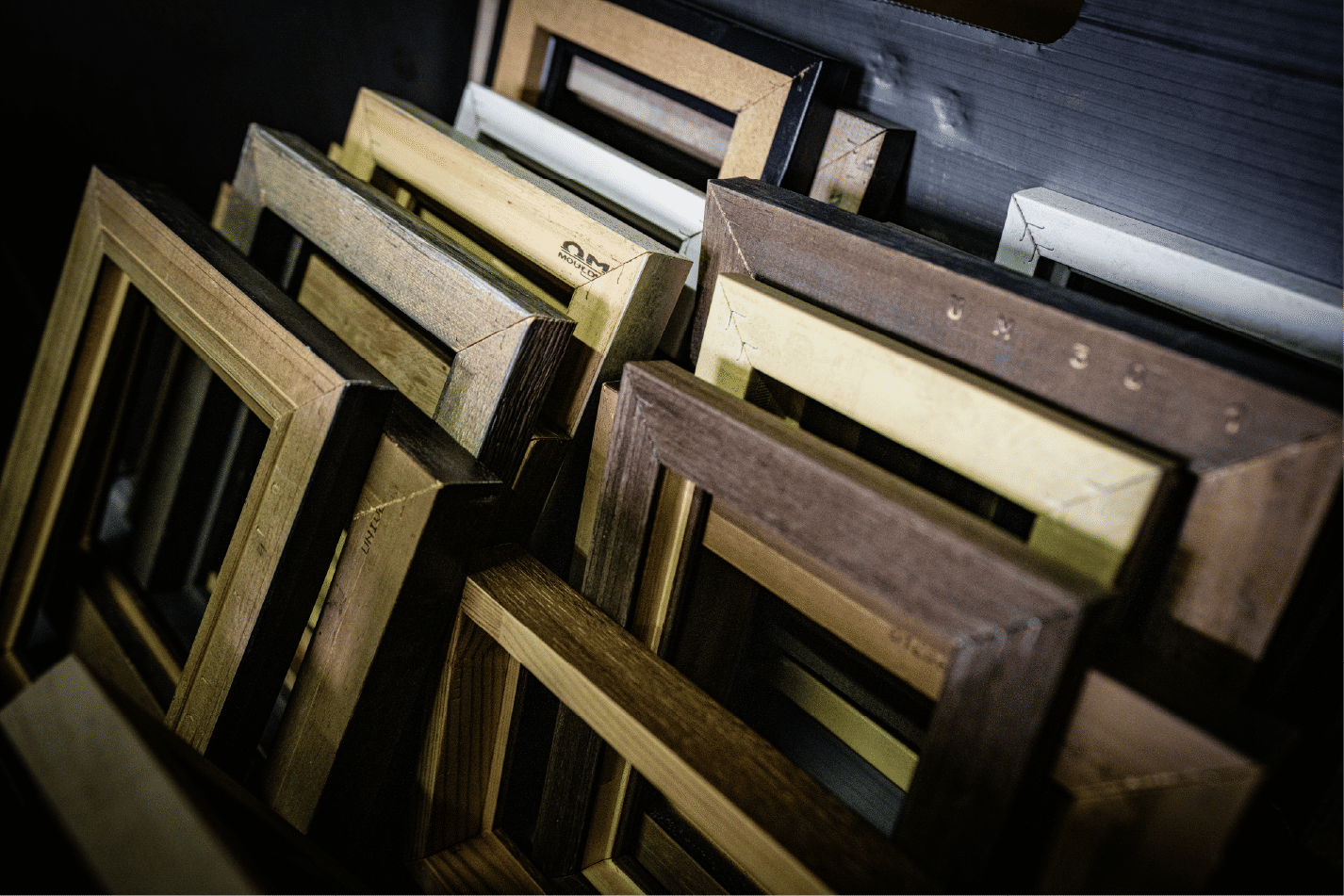 Assorted wooden frames stacked diagonally with warm tones