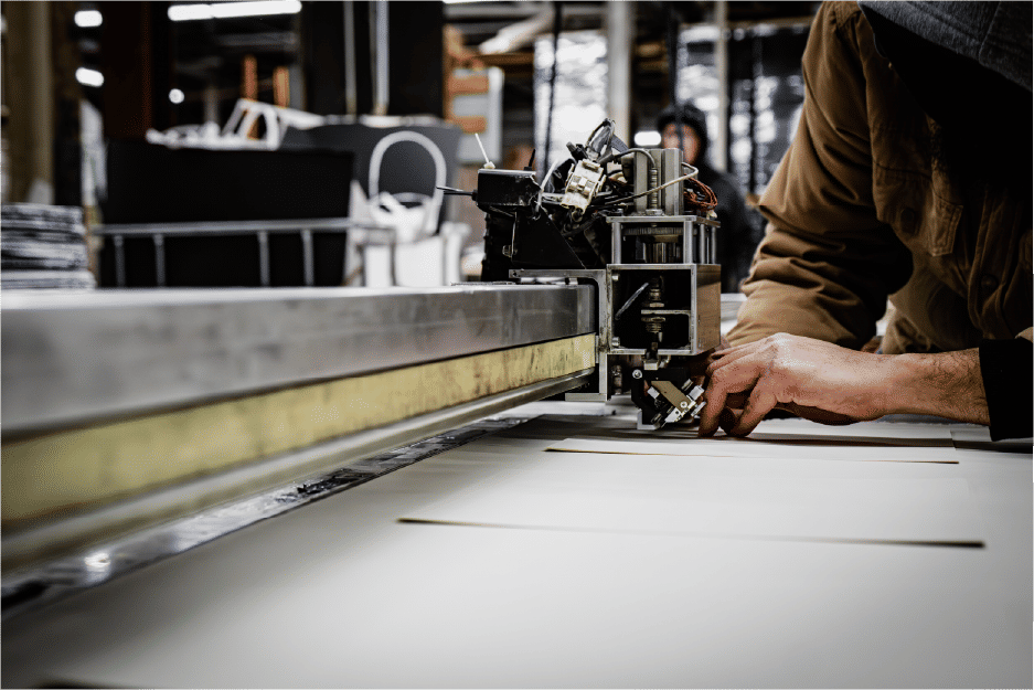 Worker adjusting industrial cutting machine during production